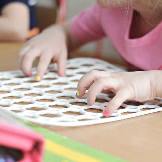 Hands using tactile letter tiles