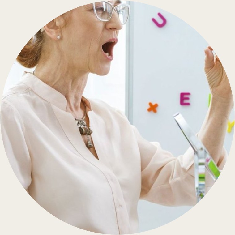 Teacher sounding out letters at a magnetic alphabet board
